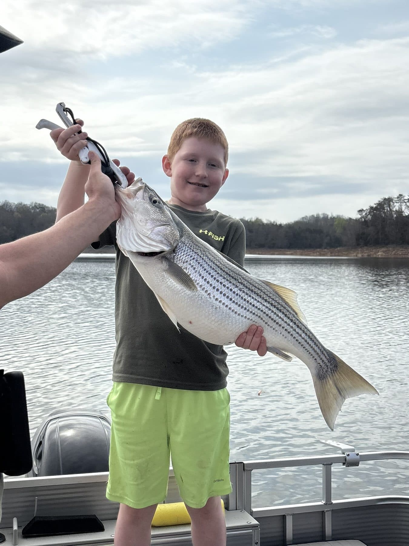 Young angler with a striper nearly his own size